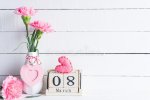 womans-day-concept-pink-carnation-flower-vase-red-heart-march-text-wooden-block-calendar-white...jpg